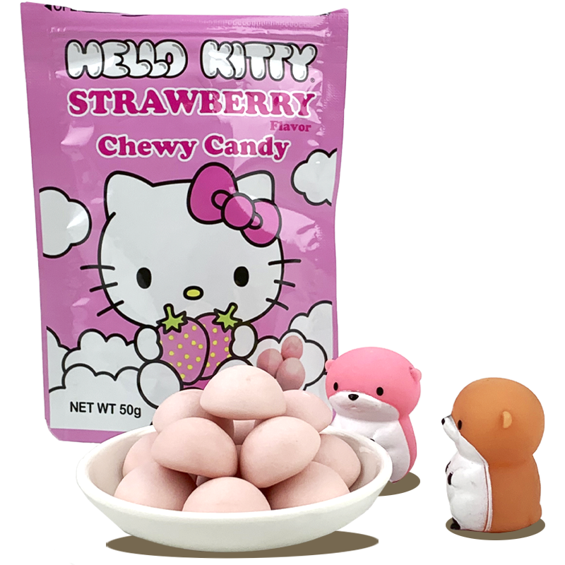 Hello Kitty strawberry-flavored chewy candy packaging features the cute Hello Kitty character holding two strawberries, surrounded by fluffy clouds, with a bowl of pink candies in the foreground and two small, colorful animal figurines next to it.