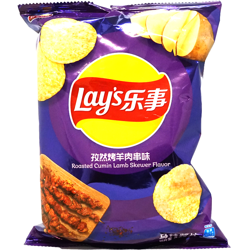 Front of package. The packaging features a bold and vibrant purple design, showcasing enticing images of the chips and a juicy lamb skewer. The dynamic colors and appetizing visuals emphasize the rich, spicy flavor inside, making the bag stand out and inviting you to try something new.