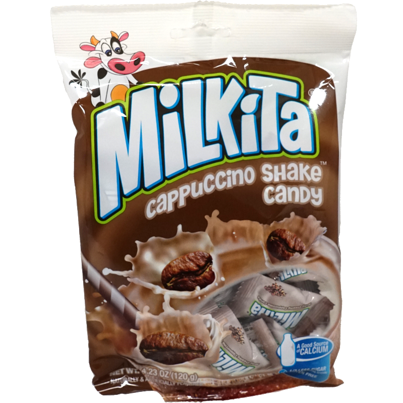 Front view of package. The package features a playful cow character in the top left corner, adding a fun and friendly touch. The main image showcases the candy pieces surrounded by a splash of creamy milk, with coffee beans emphasizing the cappuccino flavor. The overall design is vibrant and appealing, drawing attention with its inviting colors and appetizing visuals.